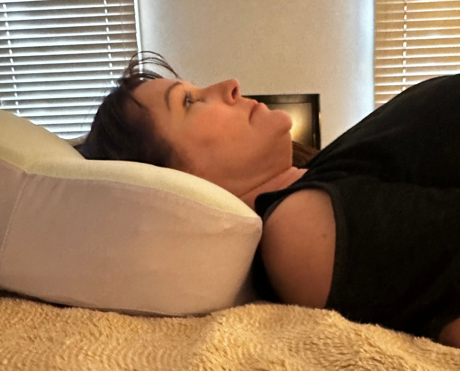 Woman lying on a flattened pillow — her head sinks back and the pillow has lost its height.