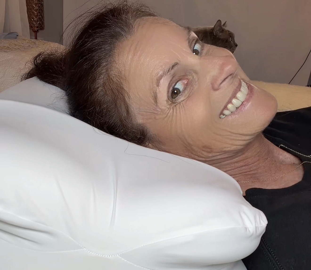 Danielle, founder of CrownLift Insert, resting on a pillow supported by the CrownLift Insert